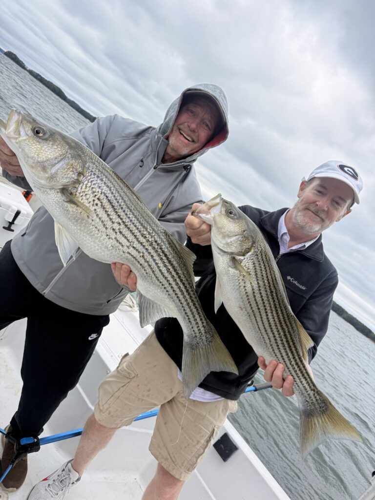 Cold Wind, Bending Rods, and My Boat’s First Trip Back Pat and Wes holding Lake Lanier stripers after fishing open water