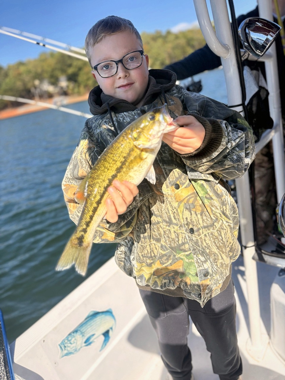 Lake Lanier Striper Fishing Report – October 24, 2026 | Tough Conditions, Quality Fish & Fall Migration Young angler holding a spotted bass during a family fishing trip on Lake Lanier
