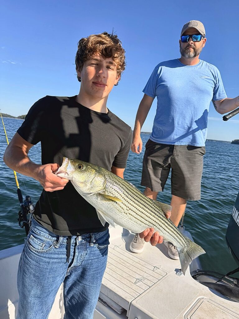 Lake Lanier Striper Fishing Report – October 12, 2026 Young angler holding a quality striped bass on Lake Lanier